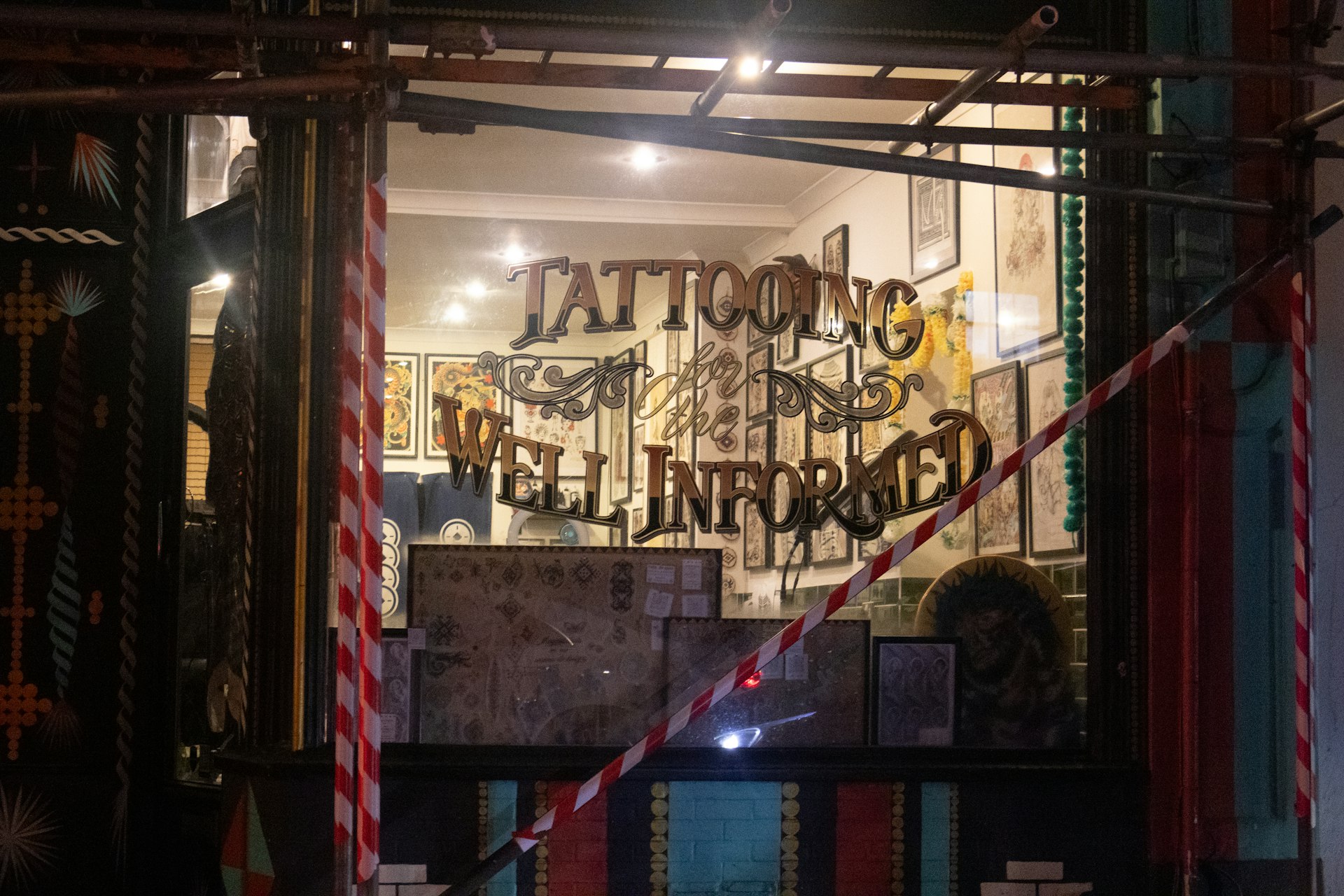 Tattoo studio window with "well informed" sign.